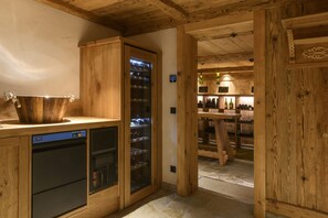 A wooden interior with a built-in refrigerator, a sink, and a wine rack. - Panorama Deluxe Mountain Hideaway House (Tschagguns)