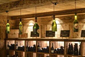 A wooden interior with hanging wine bottles and shelves of wine. - Panorama Deluxe Mountain Hideaway House (Tschagguns)