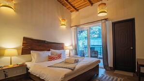 A bedroom with a wooden headboard, a bed with white linens, two bedside lamps, and a view of the outdoors through a door. - Deodar Bungalow & Cottage by Trikone (Nainital)