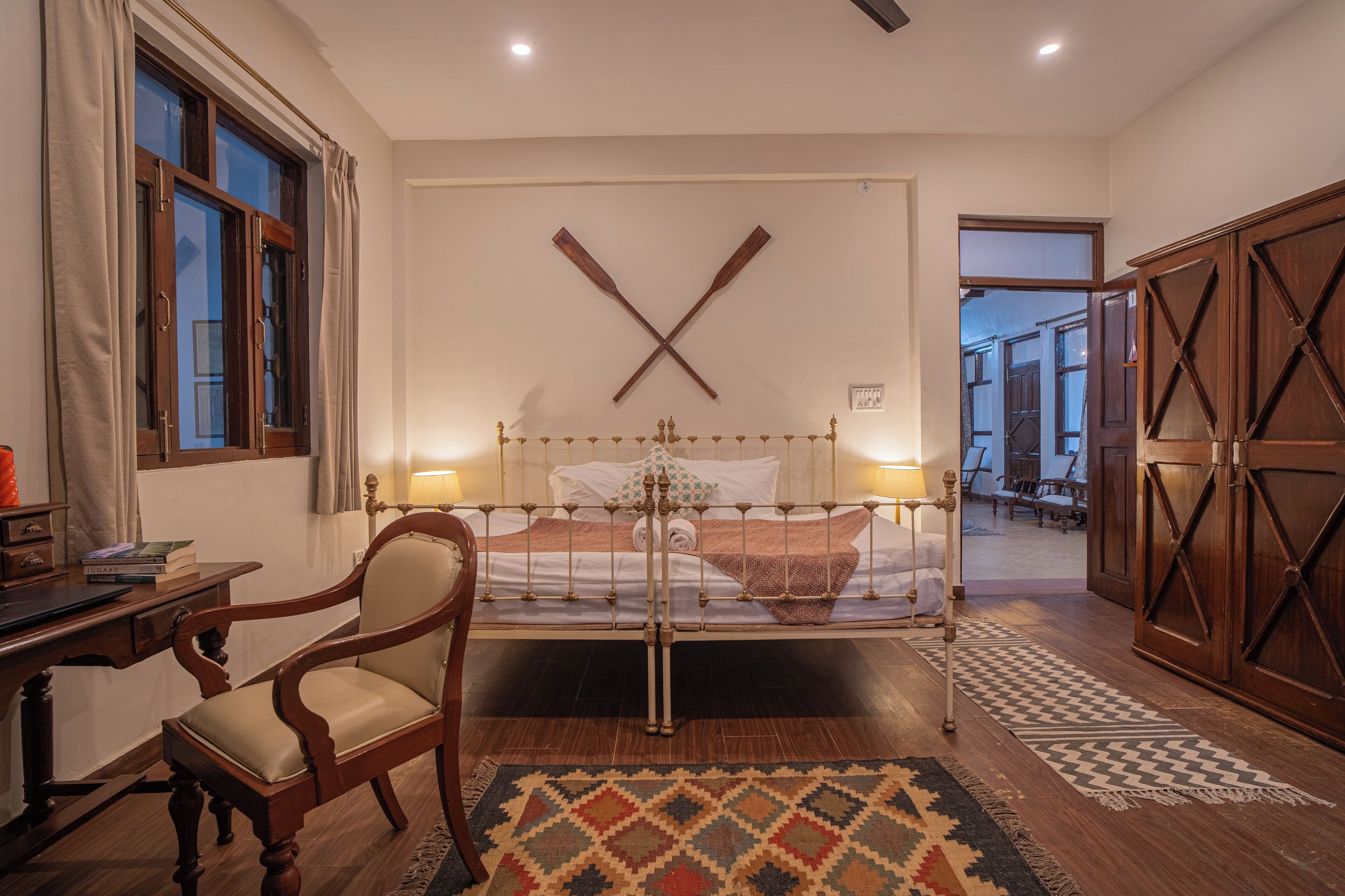 A bedroom with a bed, a chair, a desk, and a wardrobe.