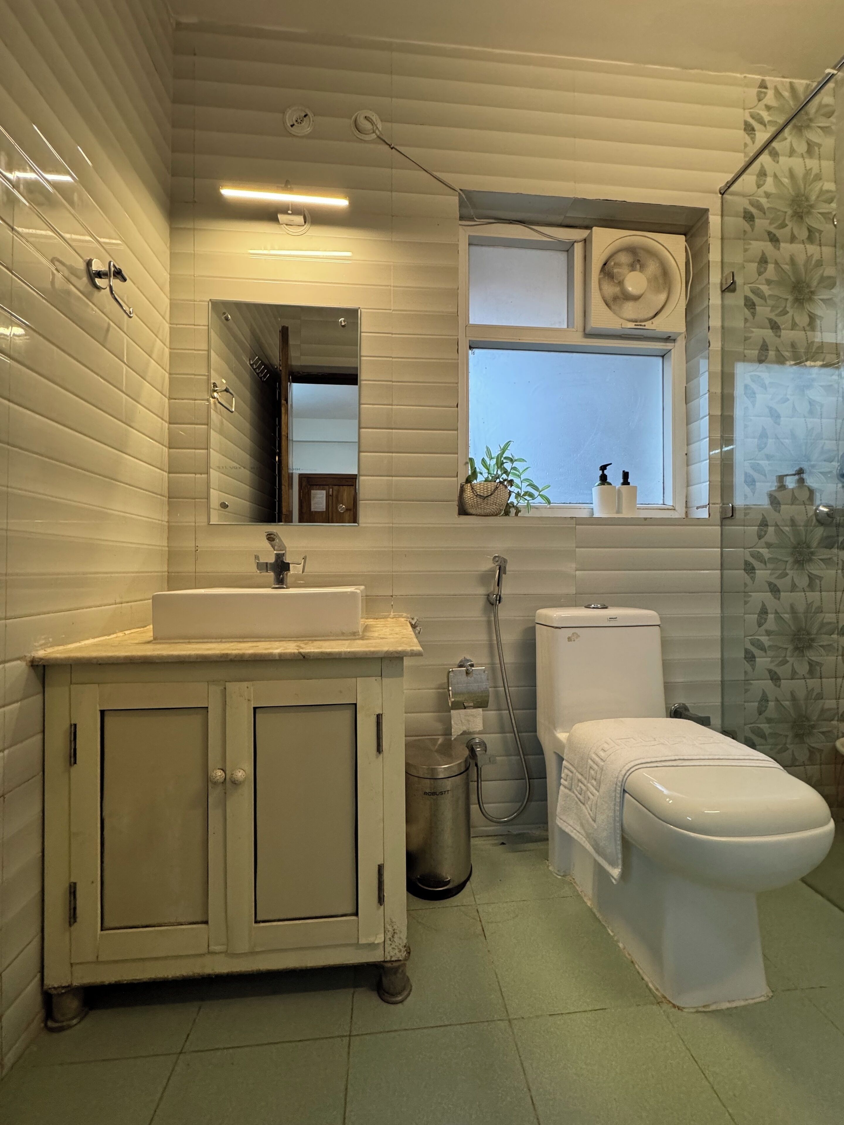 Ein Badezimmer mit Waschbecken, Spiegel, Toilette und Dusche.
