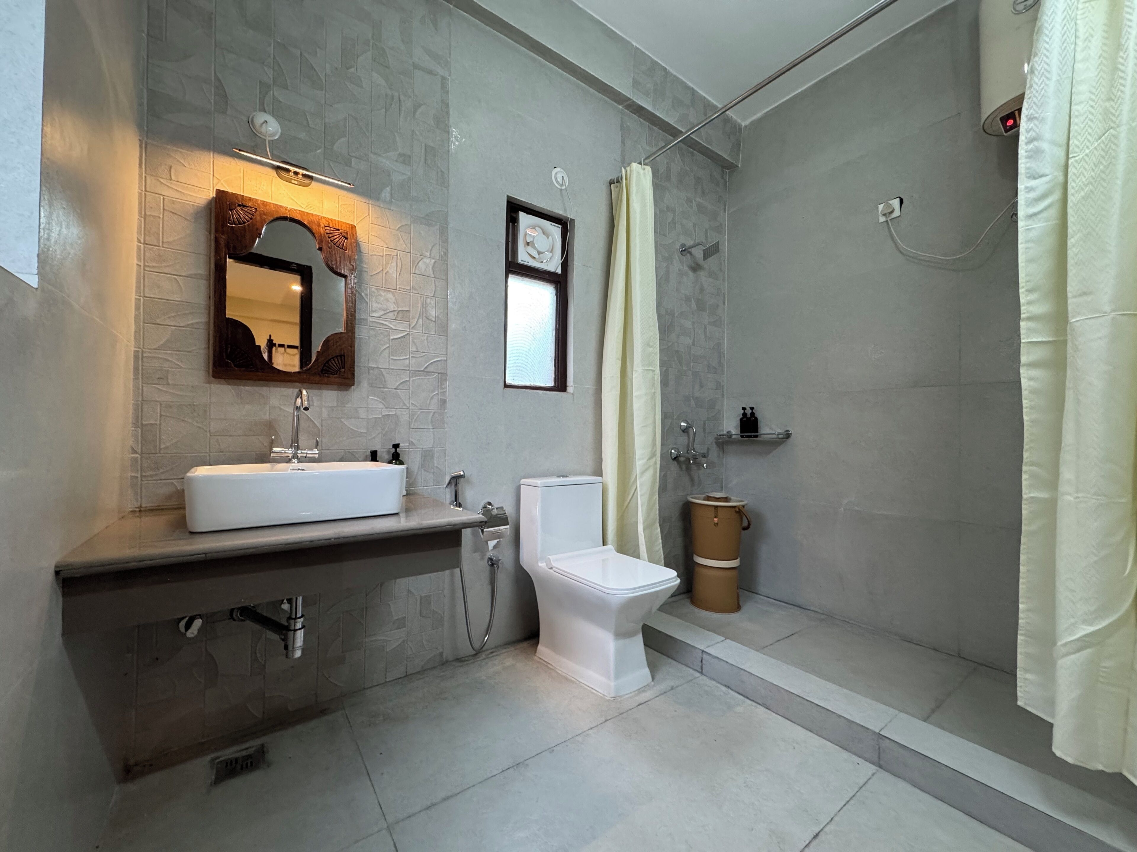 Een moderne badkamer met een grote spiegel, een wit wastafelmeubel, een toilet en een douche.