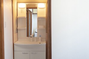A bathroom with a white sink, mirror, and cabinet. - Japanese Modern Stay｜ 5 min to Tsuruhashi station/ 5 min to Namba (Higashinari Ward)