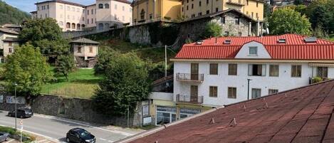 Un pueblo con edificios históricos, incluyendo una iglesia con campanario, y una carretera con coches.