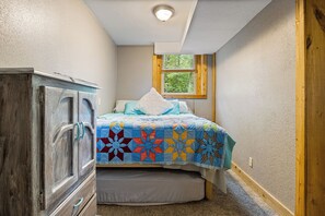 A bedroom with a bed, a wooden wardrobe, a window, and a ceiling light. - Lake of the Ozarks Apt 3 Mi to Dtwn Shops & Dining (Lake Ozark)