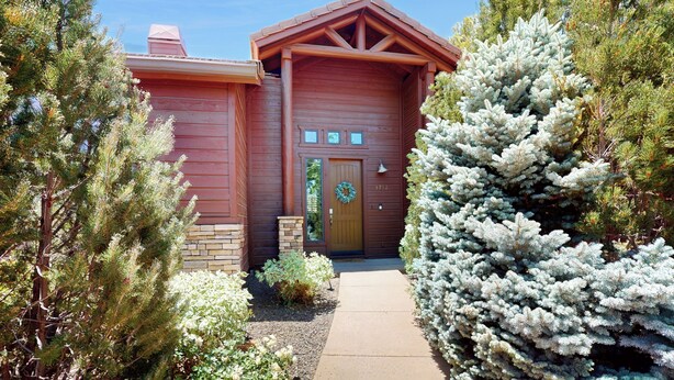 A wooden cabin with a front door, a small porch, and a wreath on the door. - Golf, Trails & Lakes! Show Low Home w/ Bonus Suite (Show Low)