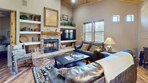 A cozy living room with a fireplace, leather sofas, and wooden shelves. - Golf, Trails & Lakes! Show Low Home w/ Bonus Suite (Show Low)