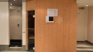 Et receptionsområde med en væg af træpaneler, en dør og et lille skærm, der viser information.