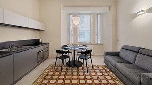 Un espace de vie compact comprenant une kitchenette, un coin repas et un espace détente.