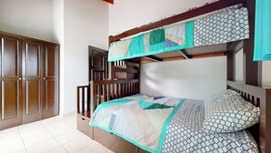 Un letto a castello con copripiumino trapuntato e cuscini decorati.