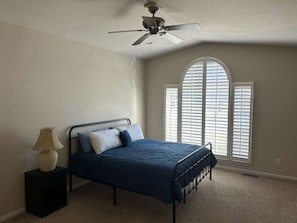 A bedroom with a bed, a ceiling fan, a lamp, and a window with blinds. - Sunset Point at Greers Ferry Lake! (Heber Springs)