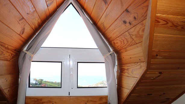 A triangular wooden ceiling with a skylight window overlooking a landscape. - Quinta do Ribeiro Real (Estreito de Câmara de Lobos)