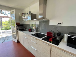 A modern kitchen with a built-in stove, a coffee maker, and a kettle on the counter. - Spanish country house with bay views A0386 (Lège-Cap-Ferret)