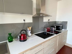 Une cuisine moderne équipée d’une cuisinière intégrée, d’une bouilloire et d’un grille-pain.