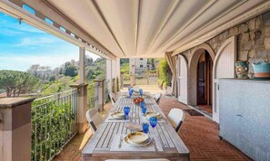 Espaço de refeições ao ar livre com uma mesa posta para dois, com vista para uma paisagem deslumbrante.