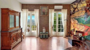 A spacious room with a large wooden cabinet, a green trunk, and a painting on the wall. - Ai Colli 136, located in the renowned Zona Colli, is the perfect choice for you!This splendid property offers a large garden, ideal for relaxing in the sun, organizing outdoor dinners or simply enjoying the tranquility of the surrounding landscape.The ho (La Spezia)