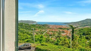 A view from a window overlooking a coastal town with a car parked in the foreground. - Reborn House is a delightful holiday home located in the panoramic area of ​​La Spezia, in via Montalbano. Perfect for those looking for a relaxing break, the house offers a splendid terrace with sea view, ideal for enjoying the tranquility of the pl (La Spezia)