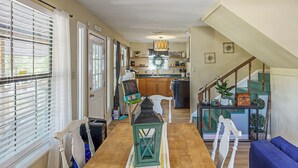 Un coin repas avec une table en bois, des chaises et une lanterne verte.