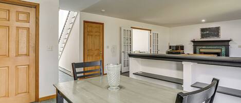 A dining area with a wooden table, chairs, and a clear glass vase.