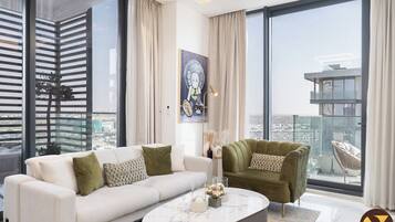 Luksusleilighet, balkong, byutsikt | Oppholdsområde | En 65-tommers smart-TV med kabel-kanaler