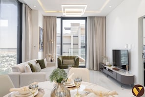 Luksusleilighet, balkong, byutsikt | Oppholdsområde | En 65-tommers smart-TV med kabel-kanaler