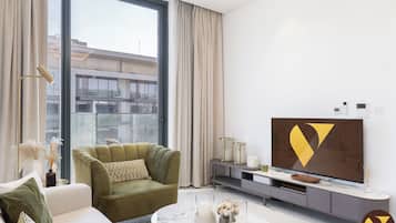 Luksusleilighet, balkong, byutsikt | Oppholdsområde | En 65-tommers smart-TV med kabel-kanaler