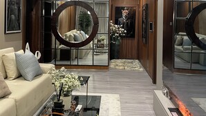 A modern living room with a sofa, coffee table, and decorative mirror. - One Bedroom Luxury apartment in Maitama, Abuja (Abuja)