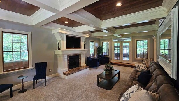 A spacious living room with a fireplace, comfortable seating, and large windows. - Creekside Haven With Dock Scenic Views (Hollywood)