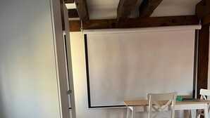 A hotel room with a bed, a desk, two chairs, and a large window.