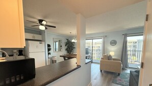 A modern apartment with a kitchen, dining area, and a balcony with a view. - Myrtle Beach Resort B0423 (Myrtle Beach)