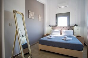 A bedroom with a bed, a large mirror, two wall-mounted lights, and a window. - Villa Alen – Exclusive Luxury Escape with Private Pool & Breathtaking Views (Chania)