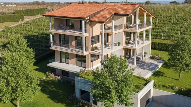 A modern multi-story building with balconies, surrounded by a well-maintained garden and vineyard. - New vacation apartments in the middle of the vineyards (Eppan an der Weinstraße)