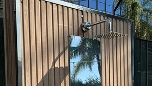 Eine Holzhütte mit Wasserhahn und kleinem Fenster.