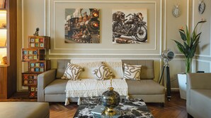 A living room with a sofa, a coffee table, and two wall-mounted paintings. - MG Luxury Stays (Panchkula)
