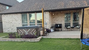 A house with a brick exterior, a covered patio, and a trampoline in the yard. - Spacious 3BR Home w/ Office & Backyard Vibes – Near Frisco. (Aubrey)