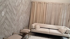 A corner room with a herringbone-patterned wall, a beige sofa, two armchairs, and a patterned rug. - Spacious 3BR Home w/ Office & Backyard Vibes – Near Frisco. (Aubrey)