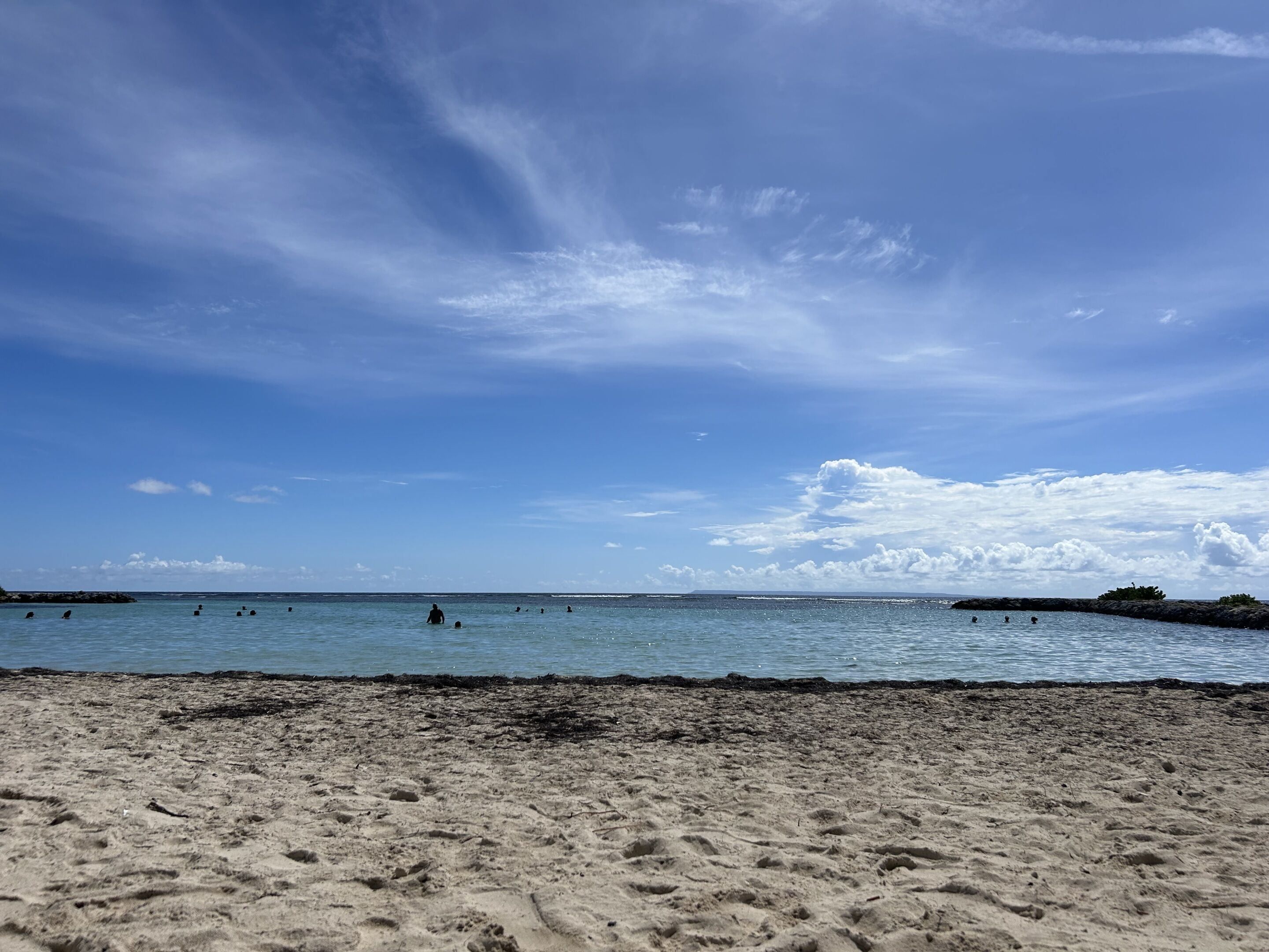 Una platja amb cel blau clar i aigües tranquil·les.