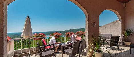 A covered outdoor seating area with a view of a mountainous landscape.