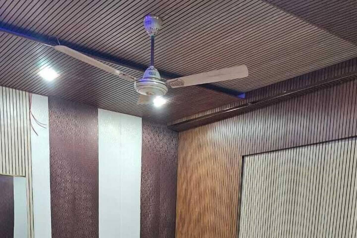 A bedroom with a bed, a ceiling fan, and a patterned floor.