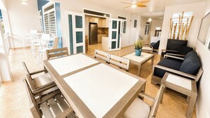 A spacious living area with a dining table, sofas, and a kitchen in the background. - Extra Large Two Story Oceanfront Home | 10 mins from Rincón & Aguadilla | ON THE BEACH SLEEPS 24 PLUS (Bo Espinar Aguada)