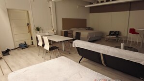 Een moderne hotelkamer met een bed, een bureau, een stoel, een klein tafeltje en een rode stoel.