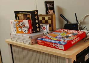A desk with board games and a computer.