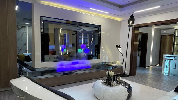 A modern living room with a large flat-screen TV, a unique white boat-shaped coffee table, and a minimalist design. - Two Bedroom Luxury Apartment in Maitama, Abuja (Abuja)