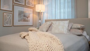 A neatly arranged bedroom with a bed, pillows, a bedside lamp, and framed artwork on the wall. - Facilities & Highlights (Timmendorfer Strand)