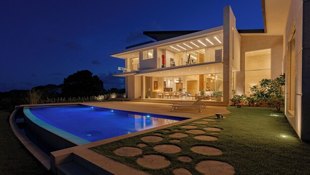A modern two-story house with a swimming pool, outdoor seating, and a well-lit patio area. - Villa Ametista a Golfer's Dream 5-BD villa in front to Punta Espada Golf Course (Punta Cana)