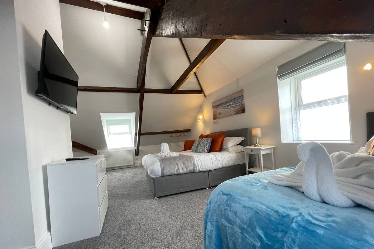 Une chambre d’hôtel avec un lit, un bureau, une chaise, une télévision et une fenêtre.