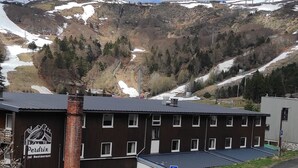 Ein Hotel mit Blick auf die Berge, ein Schild für ein Restaurant und ein Parkplatzschild.