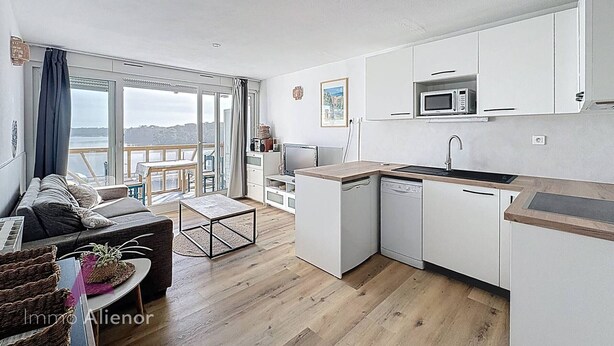 En moderne lejlighed med køkken, spiseområde og en balkon med udsigt.