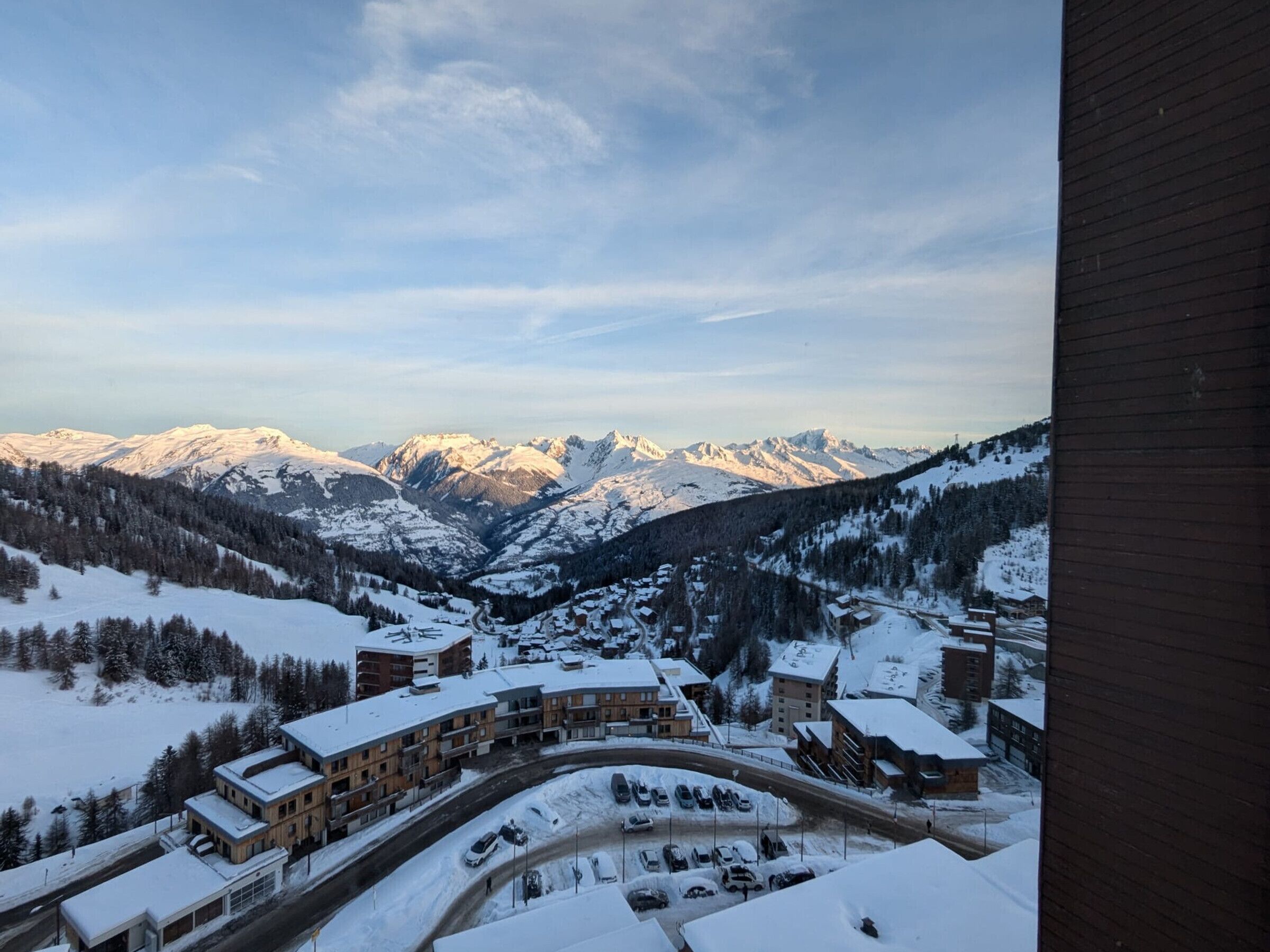 A snow-covered mountain town with a view of snow-capped peaks in the background.