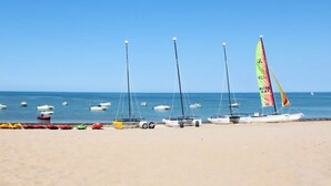 A beach with several sailboats and a few small boats anchored near the shore. - Family Mobile Home: 3 Rooms, Sleeps 4 (SAINT-HILAIRE-DE-RIEZ)
